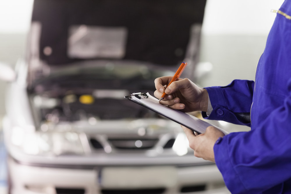 TÜV-Mitarbeiter-begutachtet-ein-Fahrzeug TÜV-Mitarbeiter-begutachtet-ein-Fahrzeug